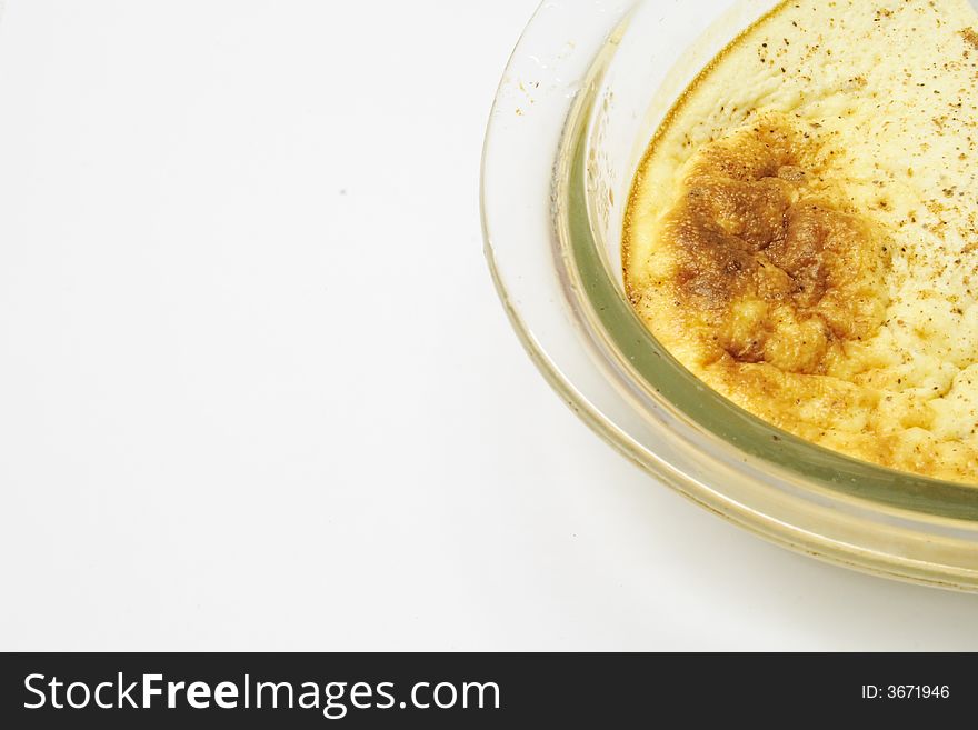 Egg custard in a glass dish over alight background