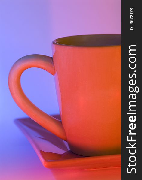 Photo of a cup & plate with dueling red and blue strobe gels