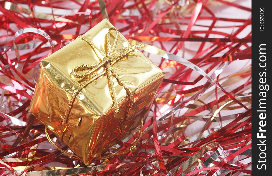 Gold gift box in red tinsel.