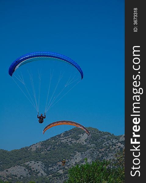 Photo of two paragliders landing after long fly over coast of the Mediterranean sea