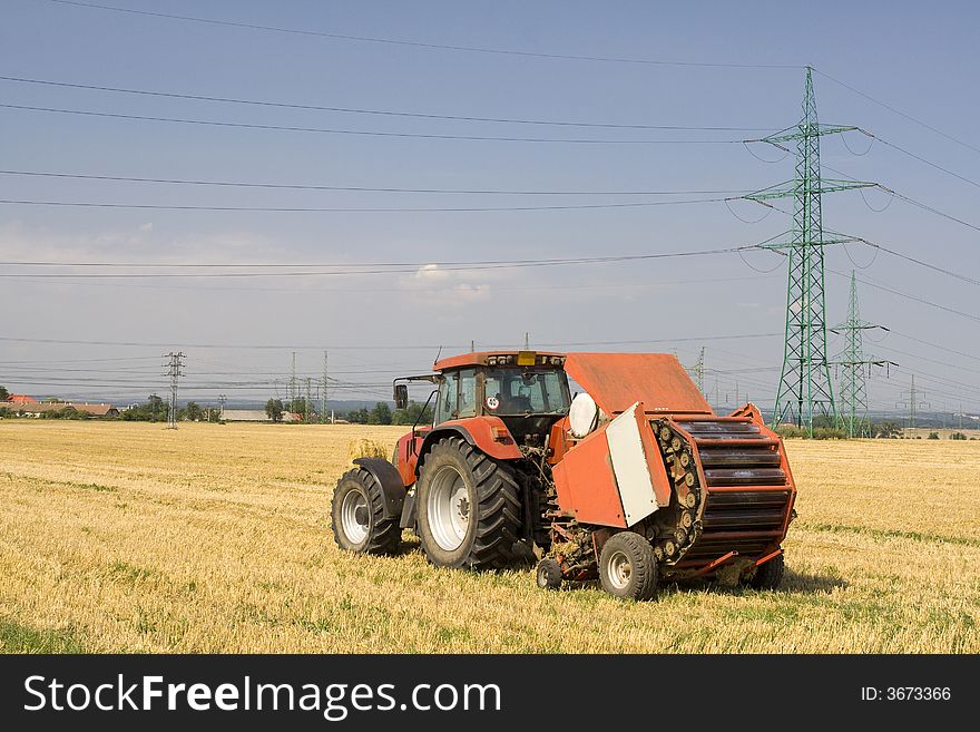 Tractor on the field with straw