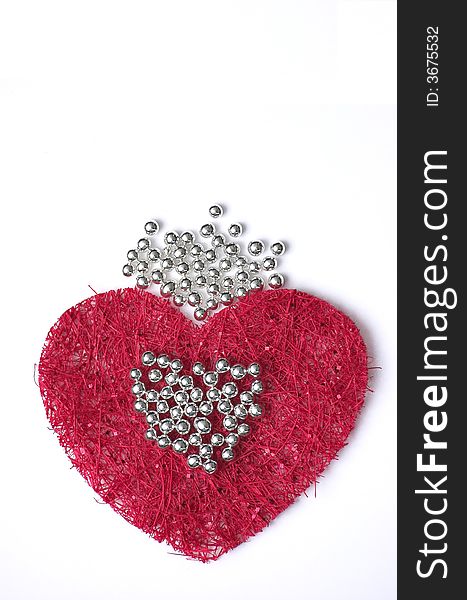 A piece of red fibre cloth forming an artificial pattern, in shape of a heart and with silver droplets on top. A piece of red fibre cloth forming an artificial pattern, in shape of a heart and with silver droplets on top