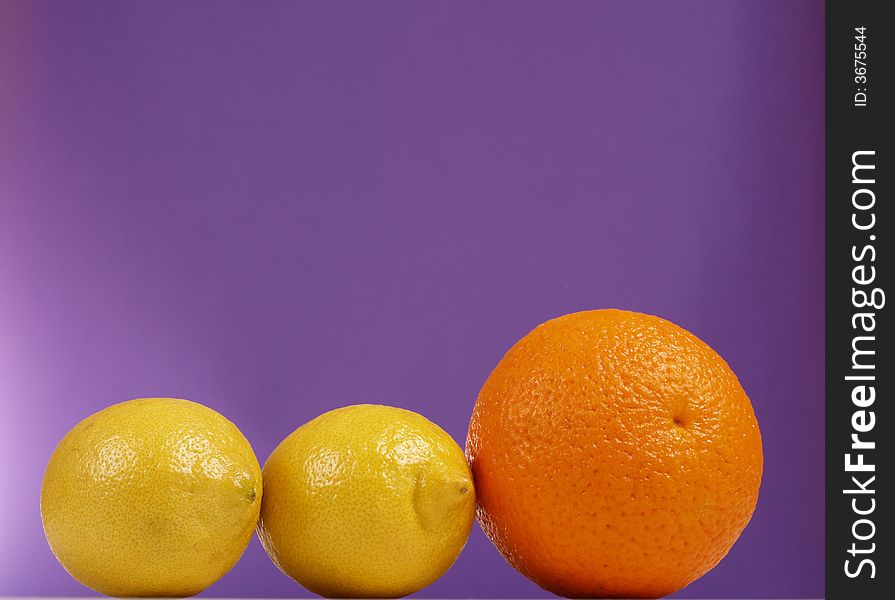 Lemon and orange on the purple background