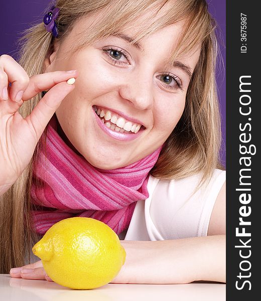 Smiling blond girl with pill on hand