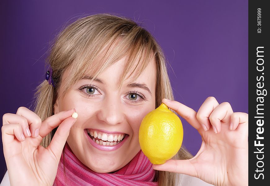 Smiling girl with lemon and pill on the hands. Smiling girl with lemon and pill on the hands