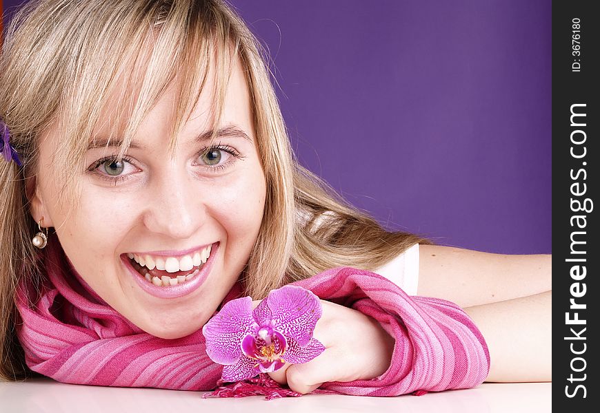 Beautiful woman with orchid in hand on the purple background. Beautiful woman with orchid in hand on the purple background.