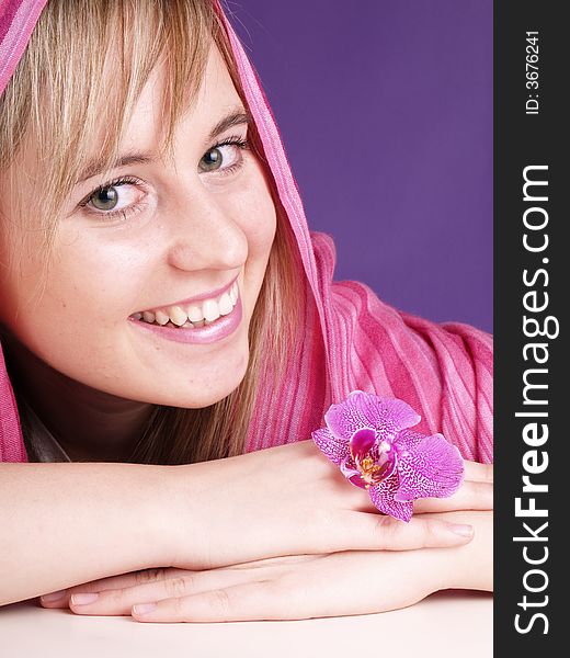 Smiling beautiful girl with pink orchid