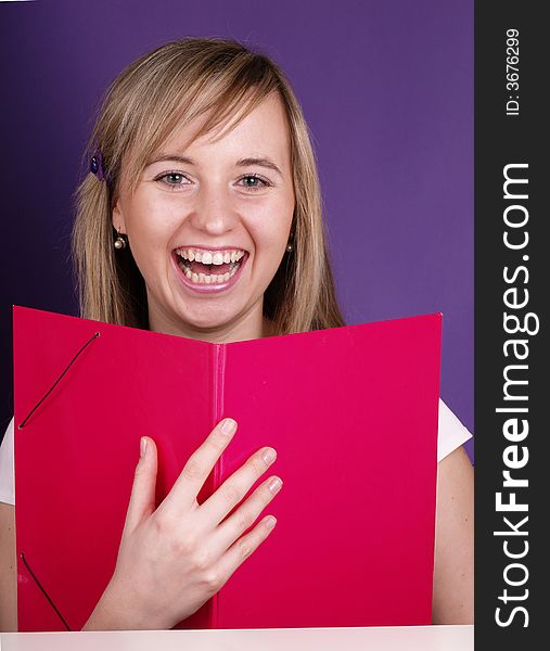Smiling blond girl on the purple background.