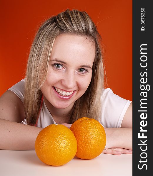 Young smiling woman with oranges.