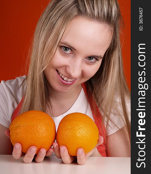 Beautiful woman with oranges in hands.