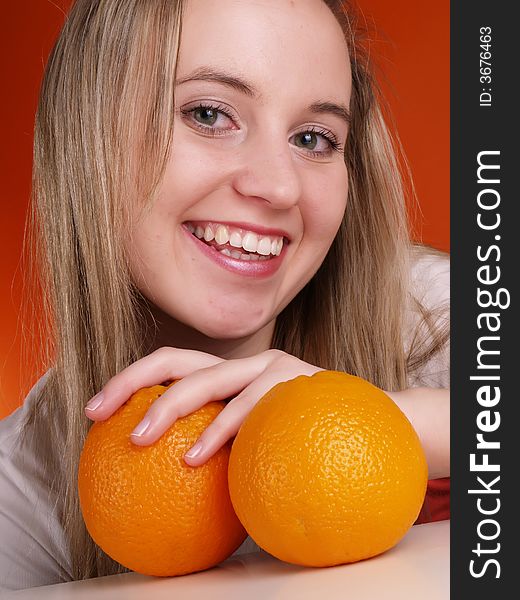 Young smiling woman with oranges.