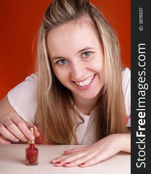 Beautiful woman applying red nail polish