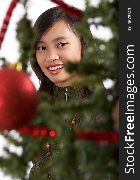 A girl peeping from a christmas tree. A girl peeping from a christmas tree