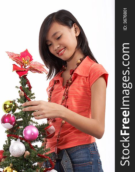 A young girl decorating a christmas tree