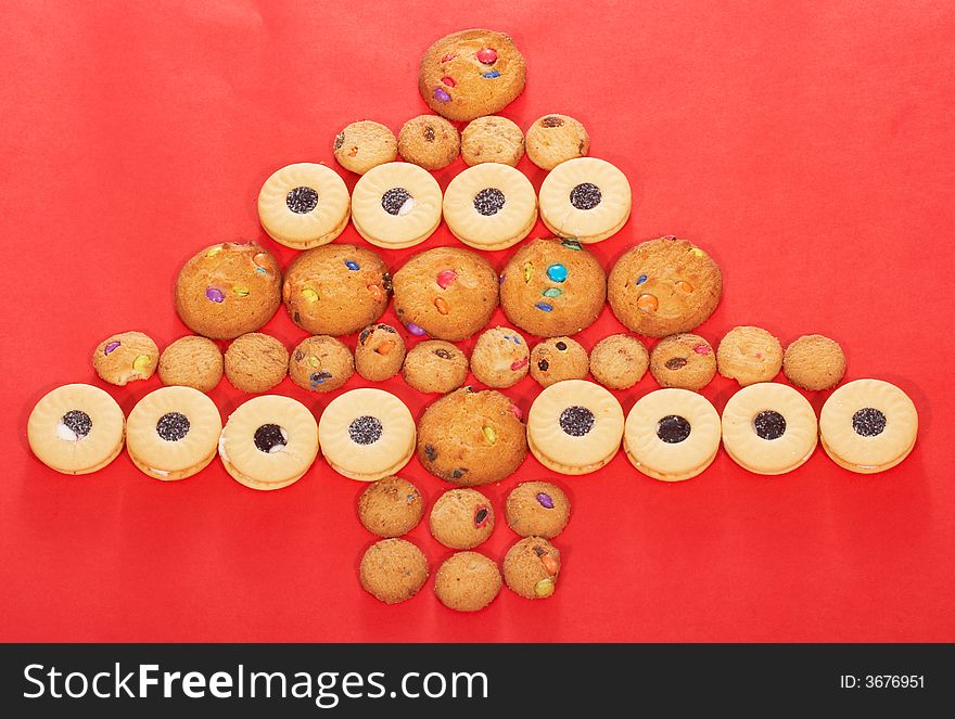 Christmas tree formed from tasty cookies on a red background. Christmas tree formed from tasty cookies on a red background