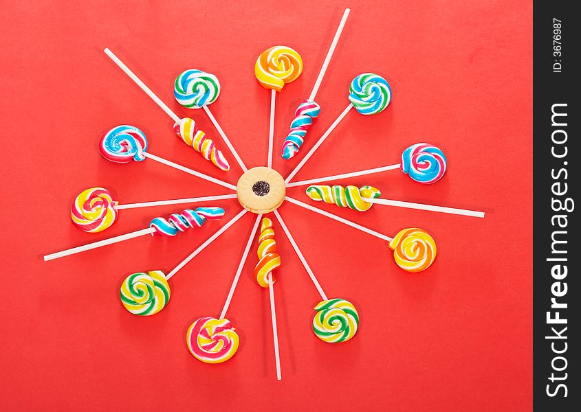 Twirl lollipop candies over a red background
