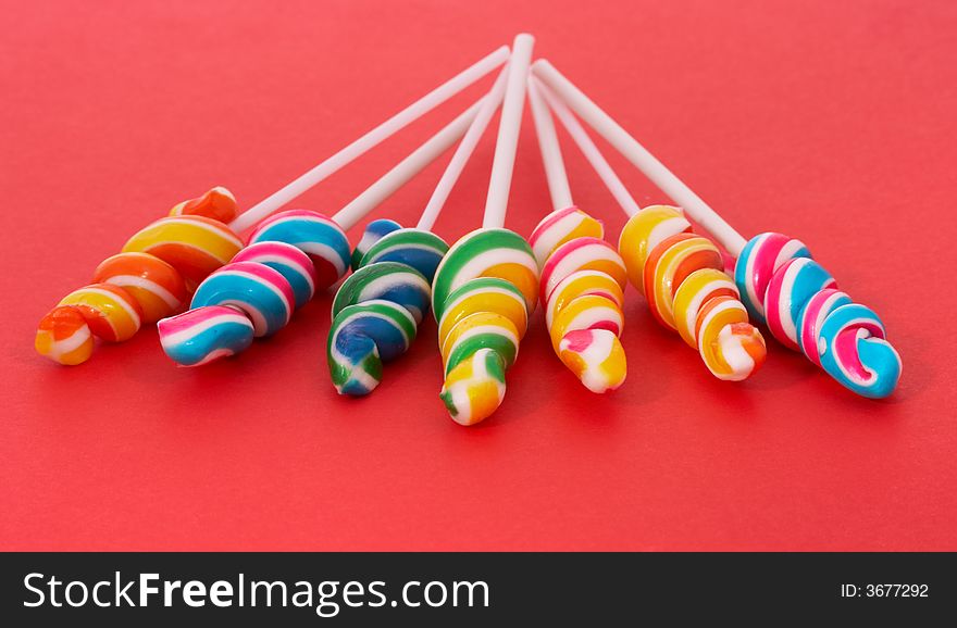 Twirl lollipop candies over a red background