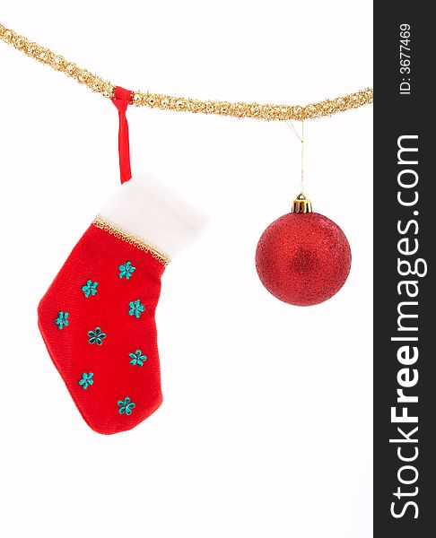 A christmas stocking and a bauble hanging over a white background