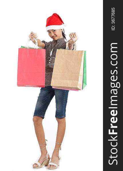 A girl wearing a christmas hat while holding some shopping bags