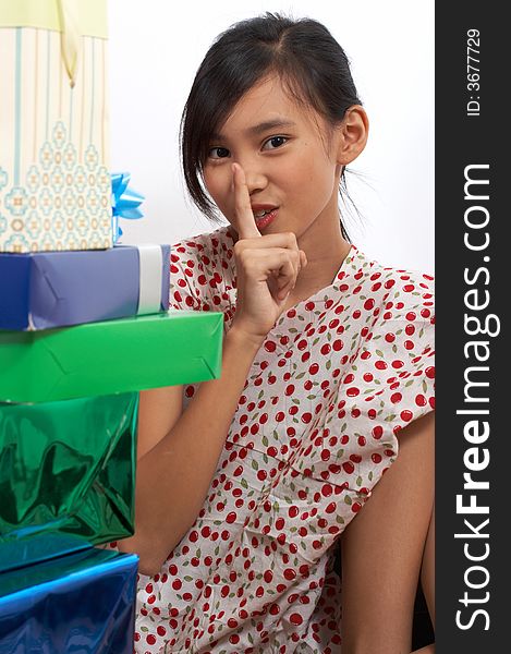 A girl sitting down behind the christmas presents