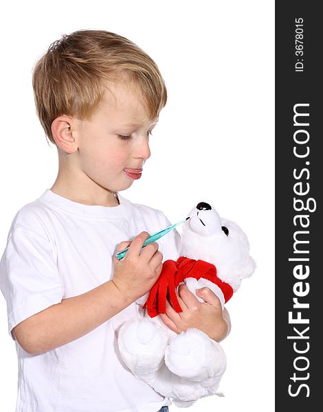 Cute young boy using a thermometer on his stuffed bear. Cute young boy using a thermometer on his stuffed bear