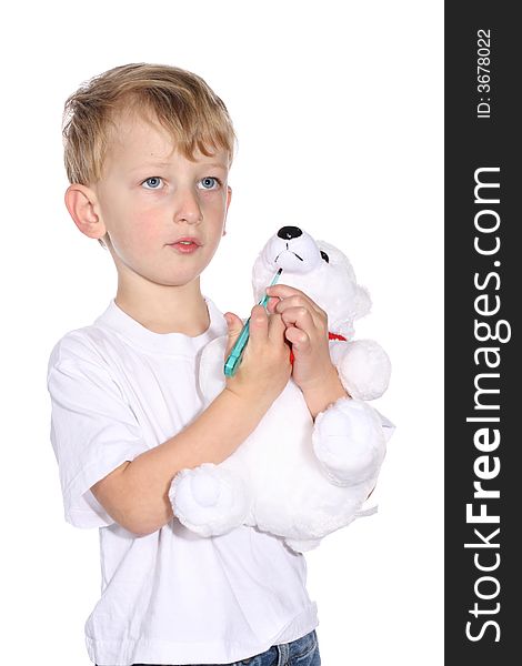 Cute young boy using a thermometer on his stuffed bear. Cute young boy using a thermometer on his stuffed bear