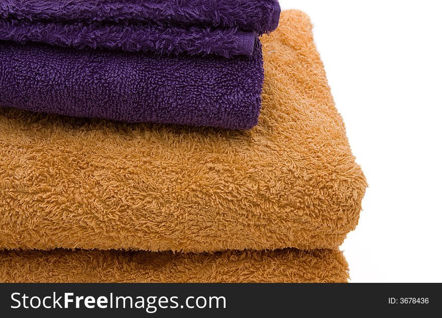 A stack of yellow and purple bath towels against a white background