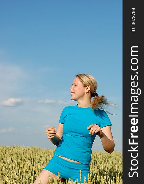 A girl in a sports wear running in the field. A girl in a sports wear running in the field