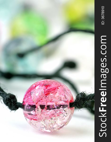 Fragment of Necklace with coloured Beads on a white background. Soft focus.