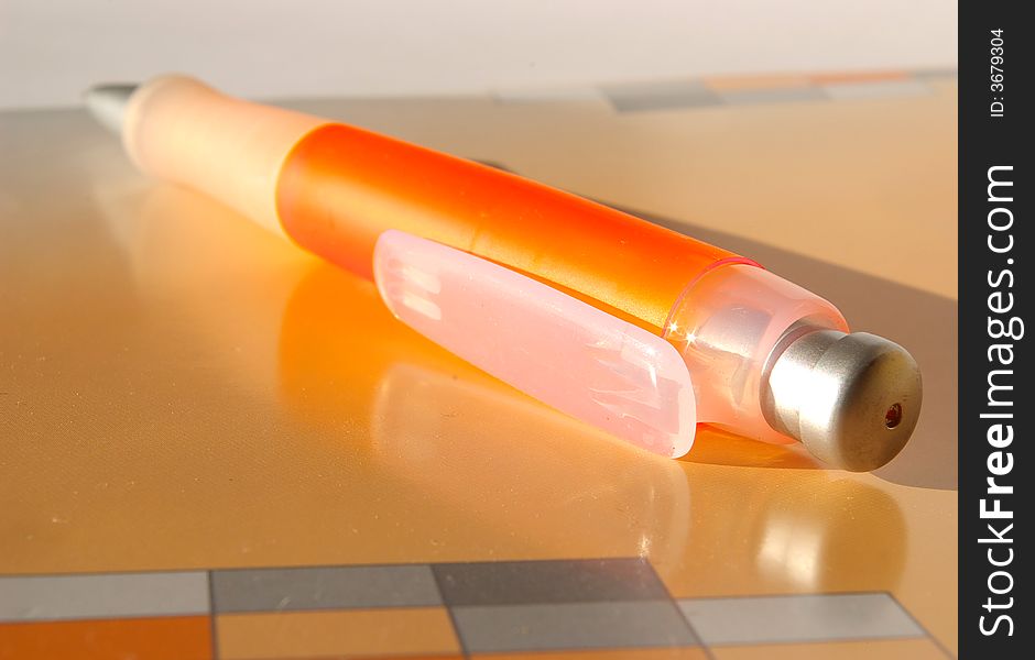 Notebook And Orange Pen