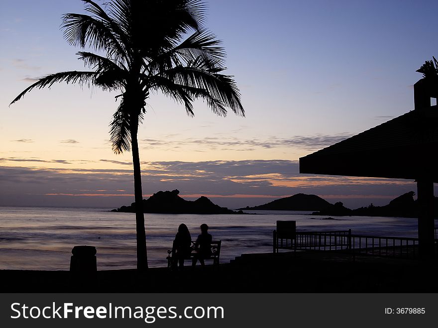 Cloudy sunrise at seaside with silhouette palm tree or coconut tree