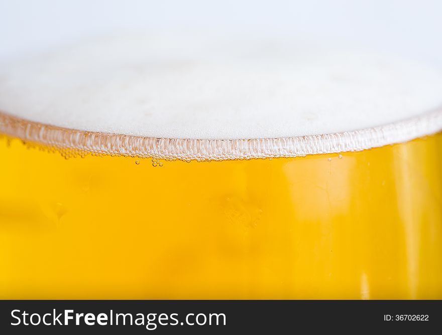 Full glass with beer and foam as background