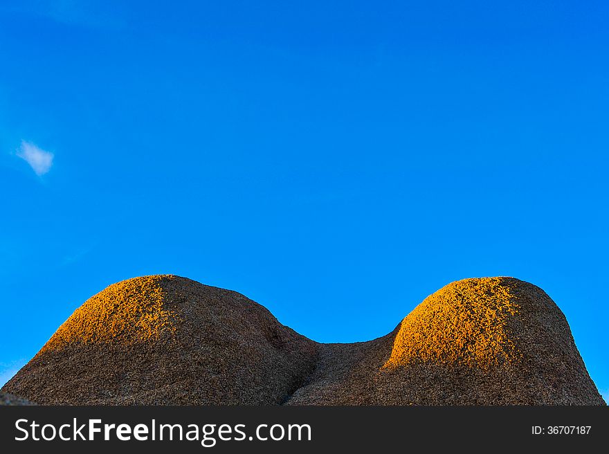 Blue sky with a mound of rocks that looks like the chest of a woman. Blue sky with a mound of rocks that looks like the chest of a woman