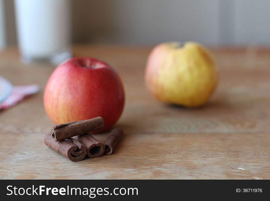 Apples with cinnamon sticks on the table