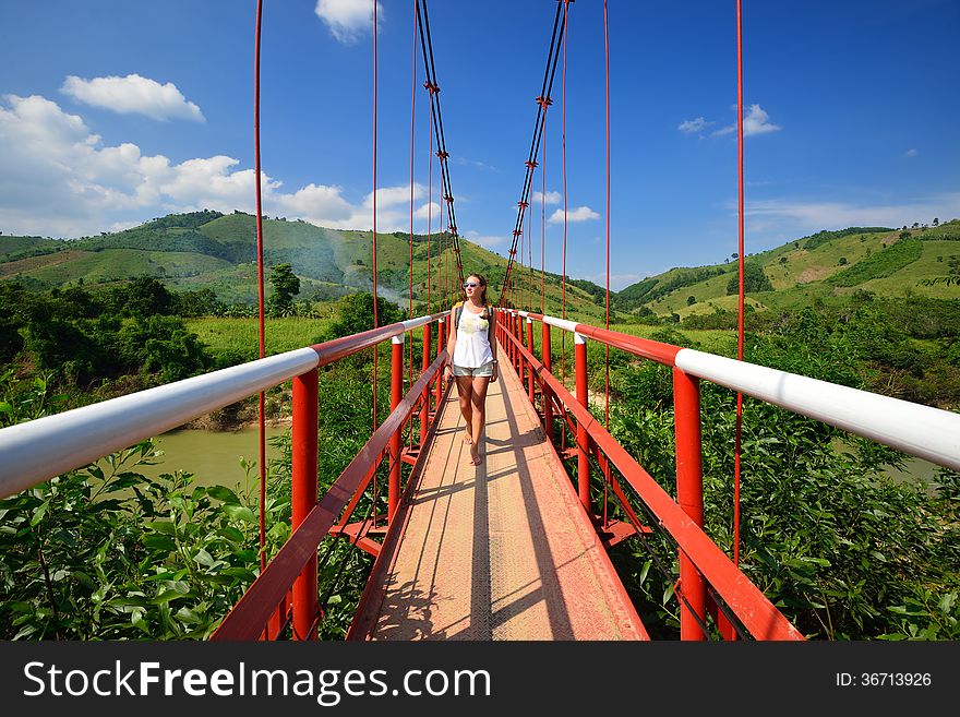 Traveler passes the river on a suspension bridge. Vietnam