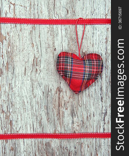 Valentine card with textile heart on old wood background