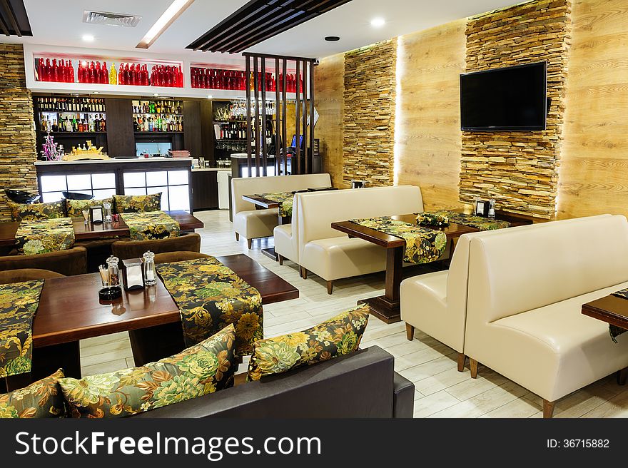 Modern restaurant interior with tables and sofas