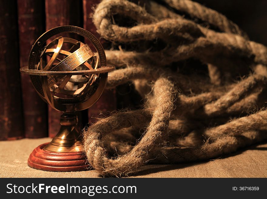 Vintage still life with Armillary sphere globe near books and rope