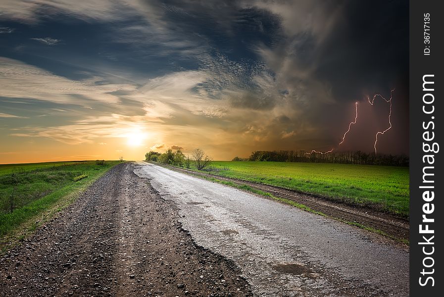 Asphalted road at sunset and stormy sky. Asphalted road at sunset and stormy sky