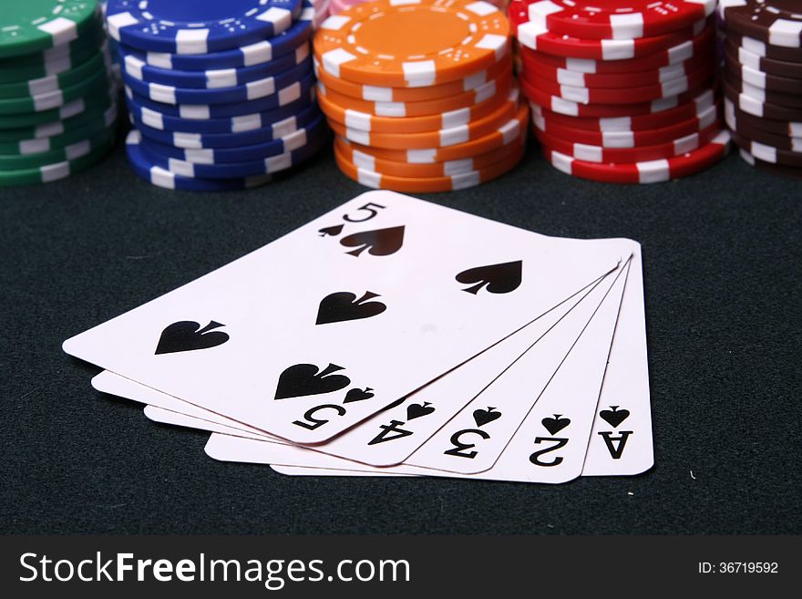 Colorful plastic chips and spade flush on the table. Colorful plastic chips and spade flush on the table.