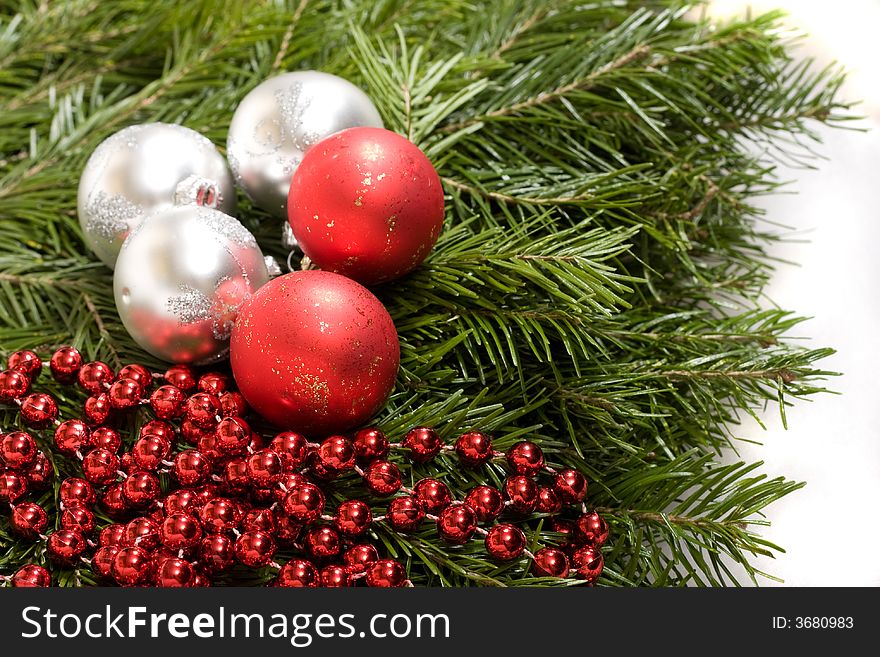 White and red christmas balls and red beads on evergreen background. White and red christmas balls and red beads on evergreen background