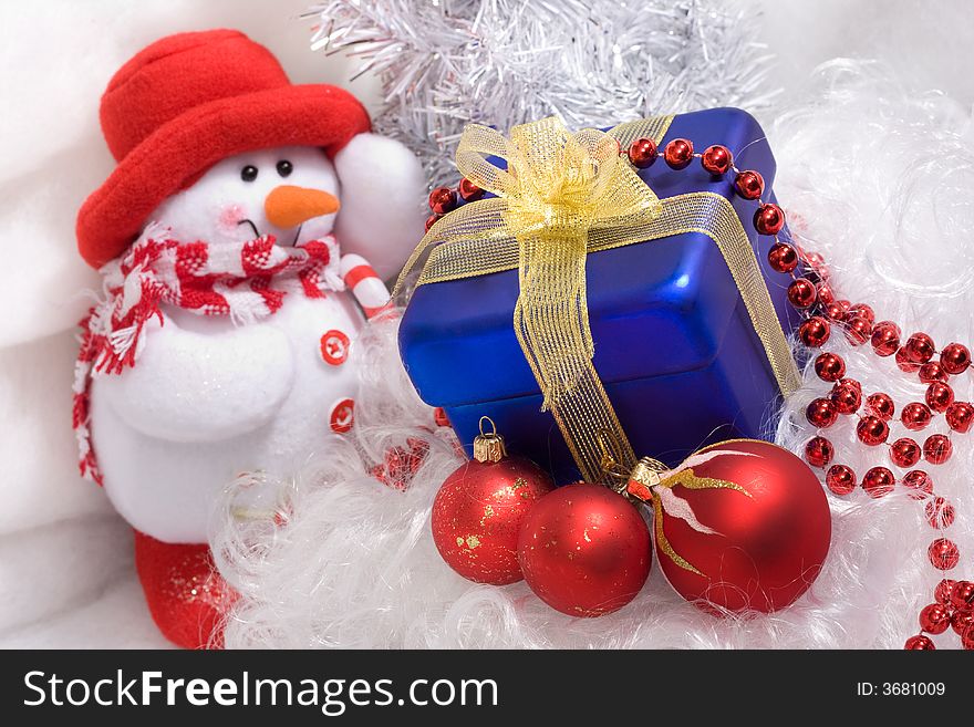 Red christmas balls and red beads, blue box with gift, and snowman. Red christmas balls and red beads, blue box with gift, and snowman