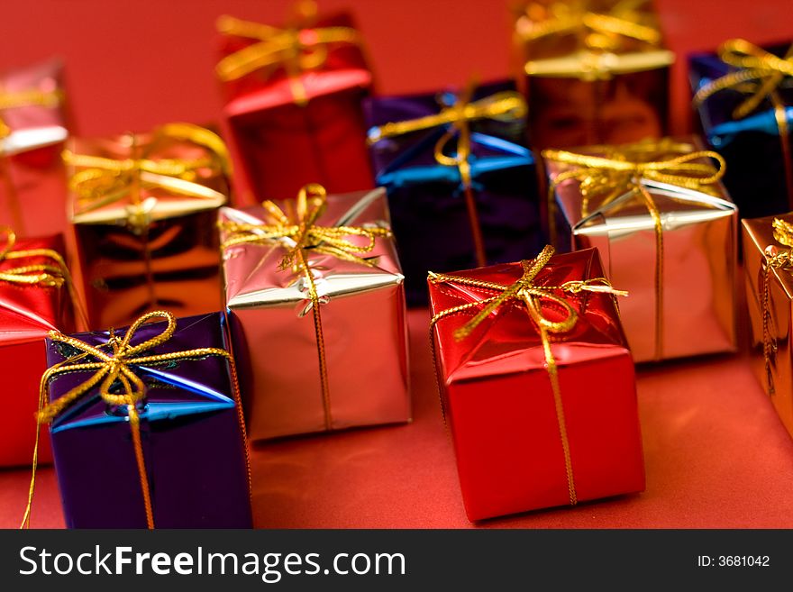 Small boxes with gifts on red background, low DOF