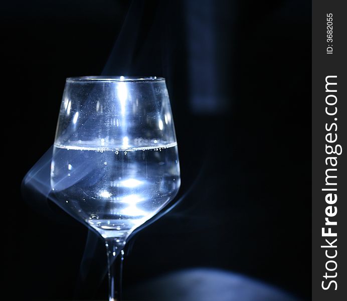 Glass with water in the dark (background). Glass with water in the dark (background).