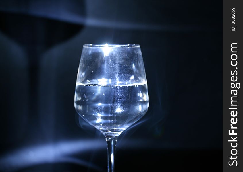 Glass with water in the dark (background). Glass with water in the dark (background).