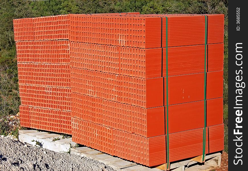Two stacks of red bricks ready to be used in a construction site. Two stacks of red bricks ready to be used in a construction site