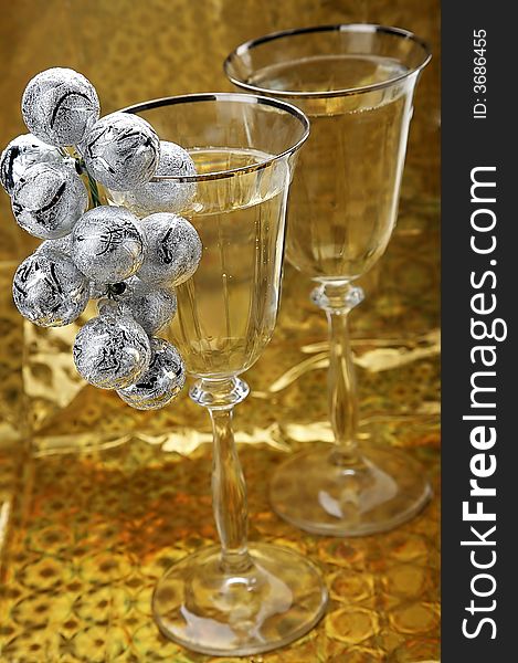 glasses of champagne with christmas decoration on golden background. glasses of champagne with christmas decoration on golden background