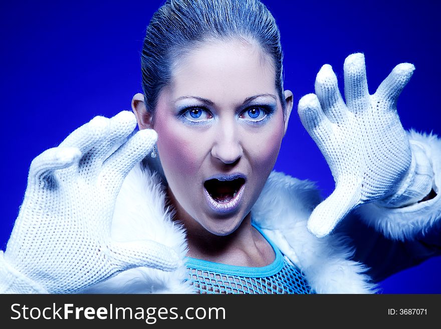 Young woman shouting at the camera on a blue background. Young woman shouting at the camera on a blue background