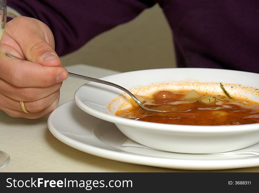 Plate with Russian soup -borshch and man's hand. Plate with Russian soup -borshch and man's hand