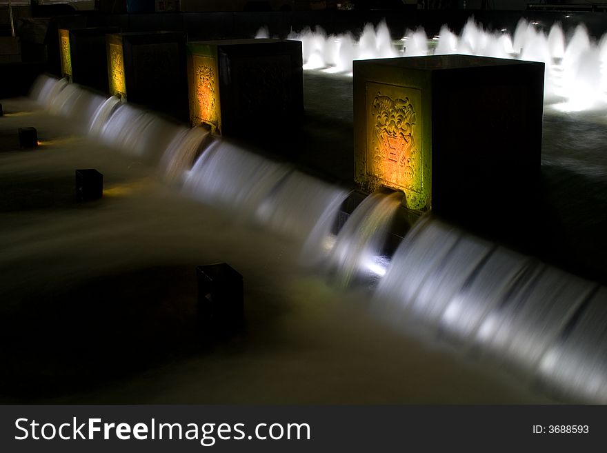 Water fountain at night with colorful lights and cubes with ornament